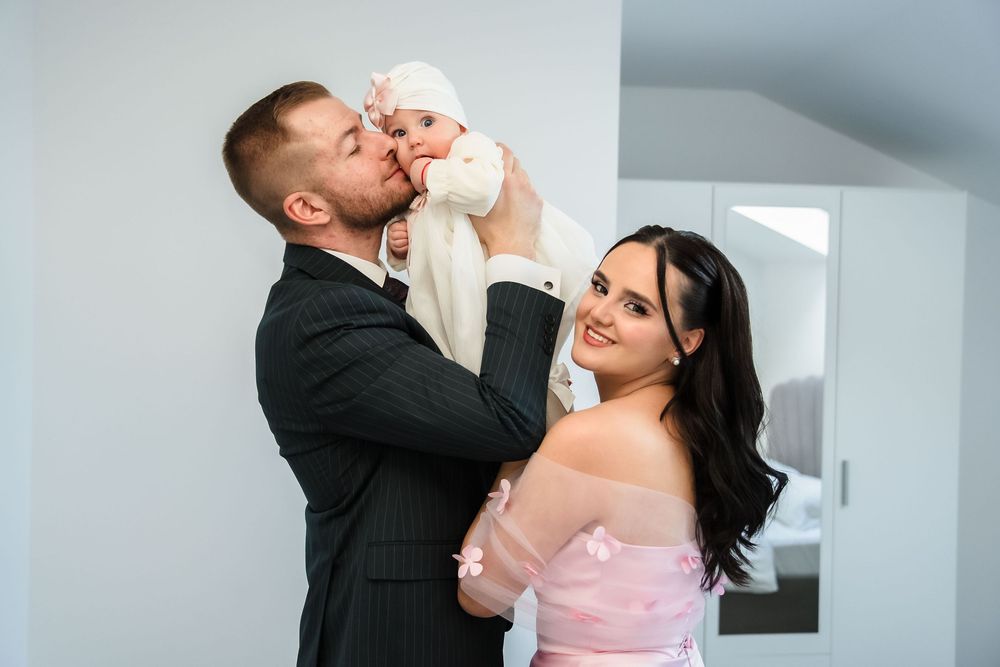 A couple in formal attire shares a romantic moment during a dance, with the bride wearing a pink gown.