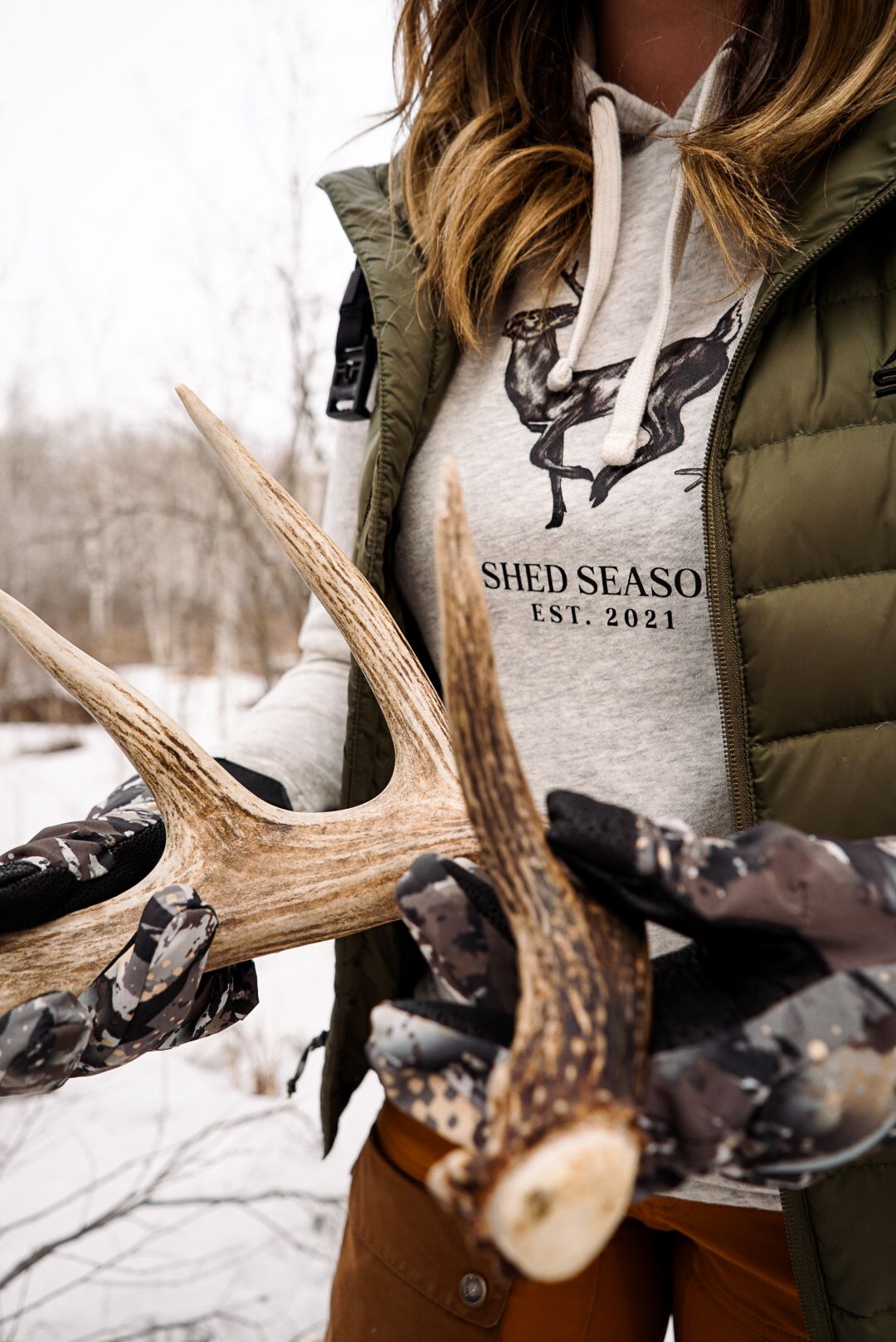 Collection of shed deer antlers displayed with Shed Season branded merchandise.