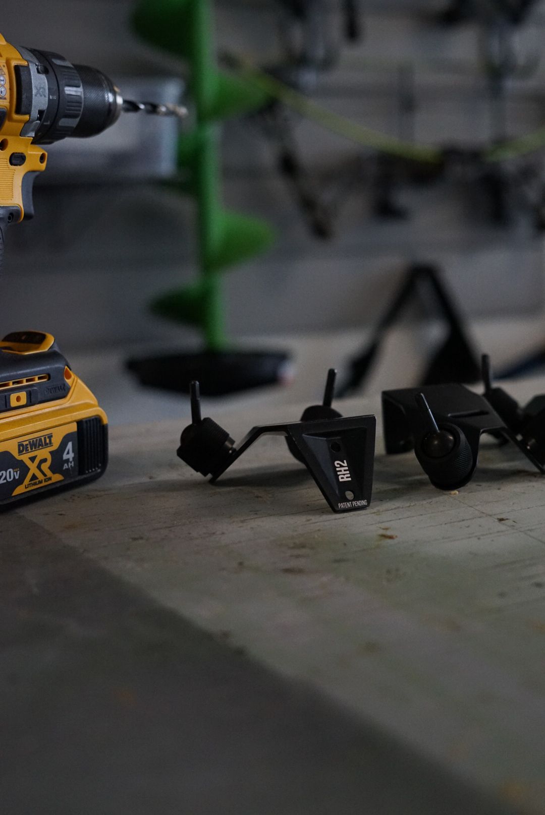 DeWalt power drill and mounting brackets on concrete workshop surface.