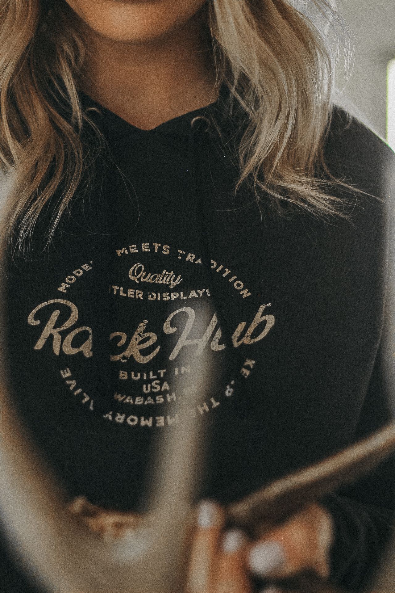 Close-up of a black hoodie with vintage-style 'Race Hub' text graphic design.