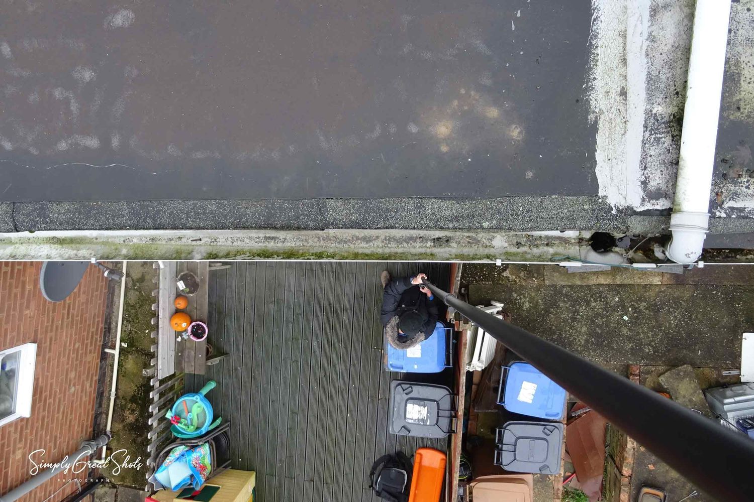 A camera mast inspecting the guttering of a residential house.