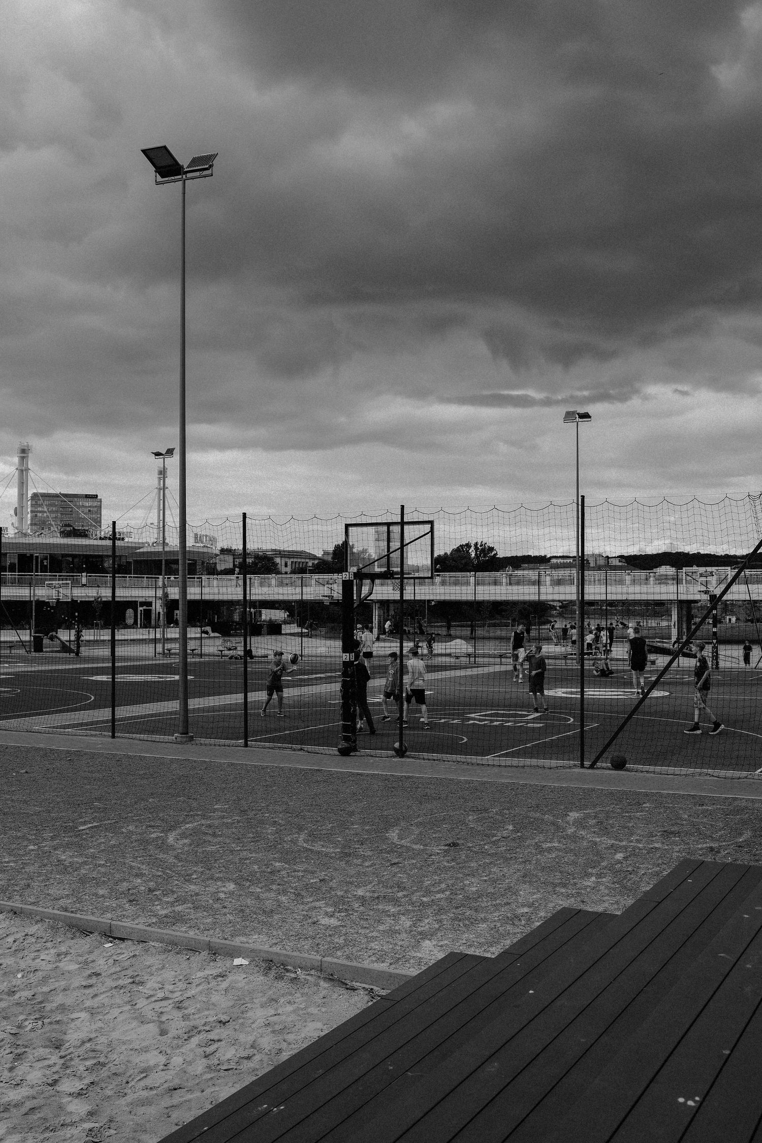 children playing basketball in Vilnius near CUP.  black and white photography. It's a nasty day