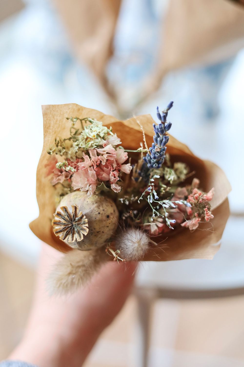 Delicate dried flowers and botanical elements in muted pink and purple tones.
