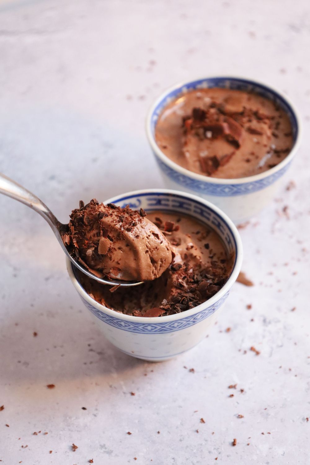 Sequence showing chocolate mousse being scooped from decorative blue and white bowls.
