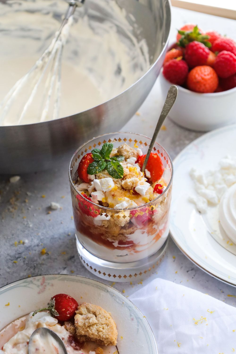 Berry parfait with crumbled cookies and whipped cream served in crystal bowls.