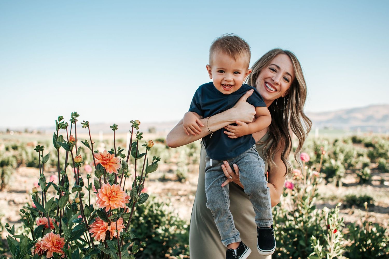 Mother and child sharing joyful moment among desert wildflowers in Washington.