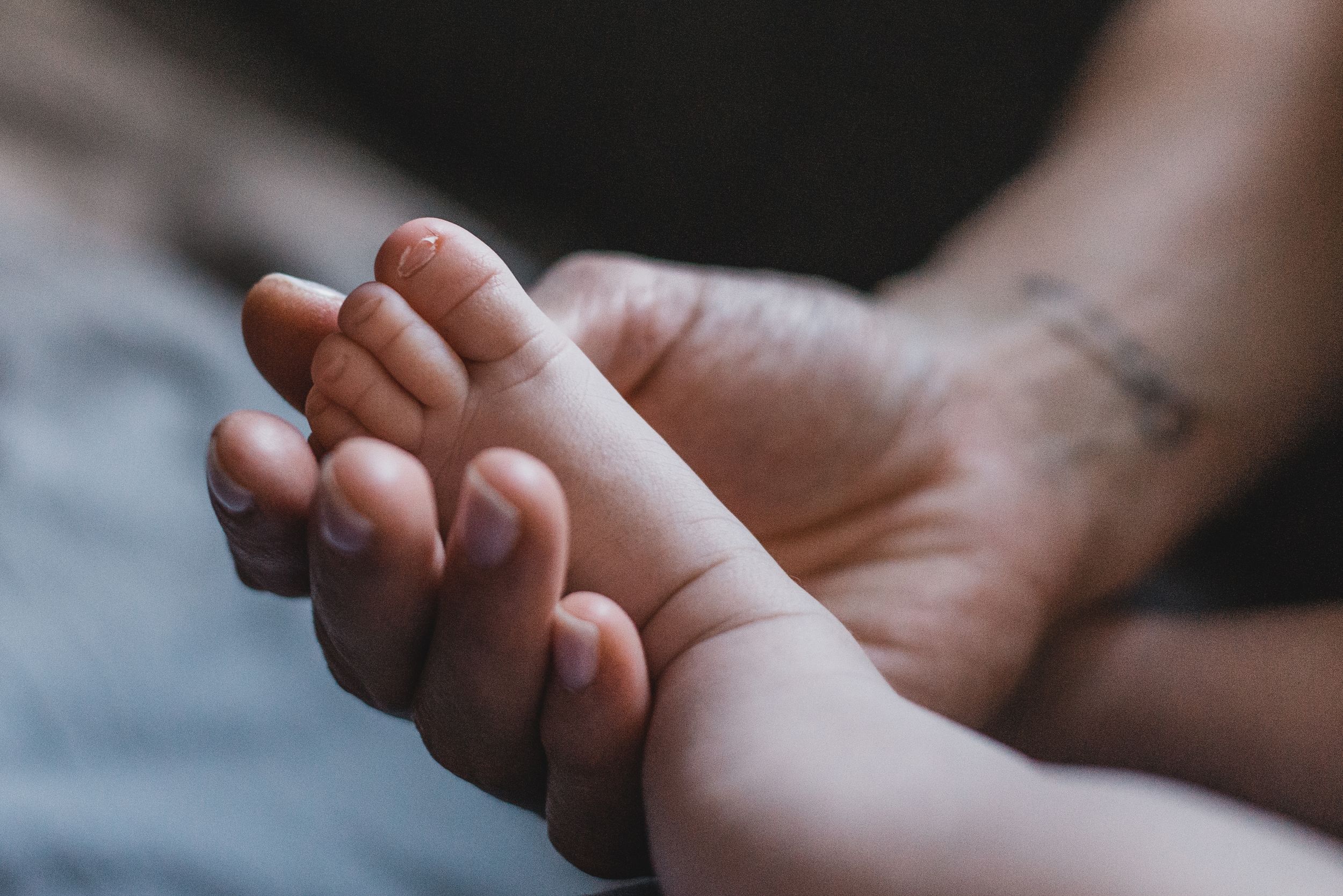 mano de madre sosteniendo piecito de su bebé recién nacido