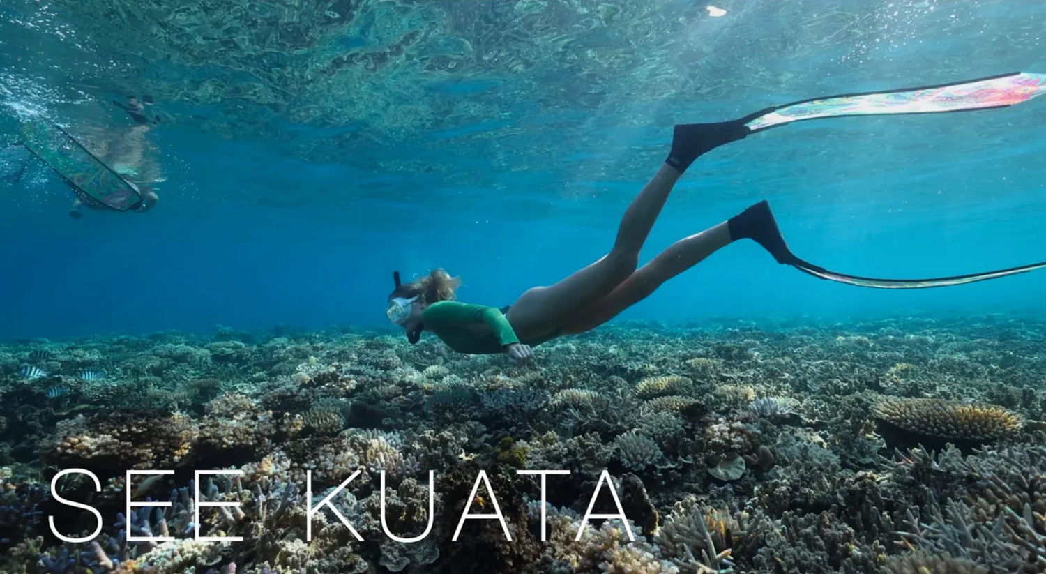 Snorkeler explores vibrant coral reef in crystal clear turquoise waters.