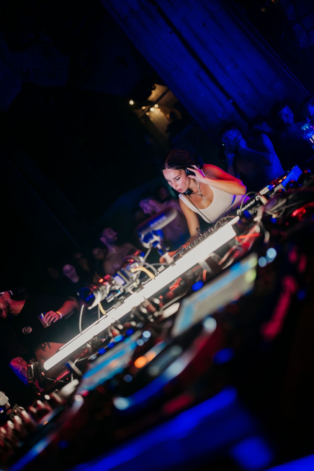 Professional DJ equipment captured at dynamic angle with blue stage lighting.