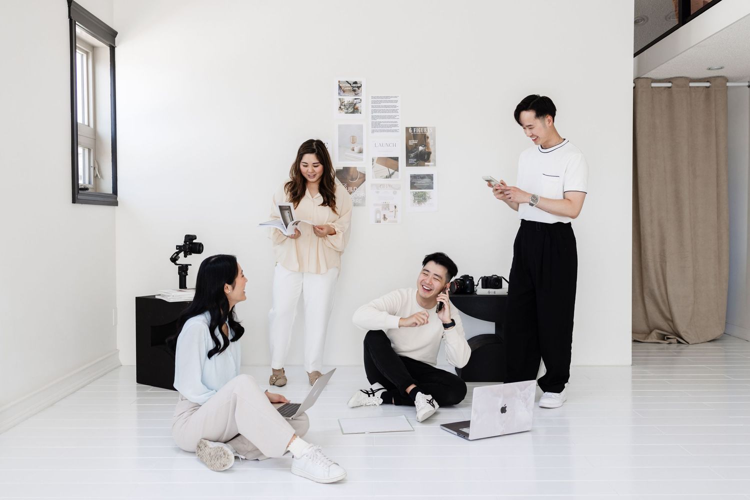Minimalist photo series showing two people working and relaxing in a bright white room with laptops and casual attire.