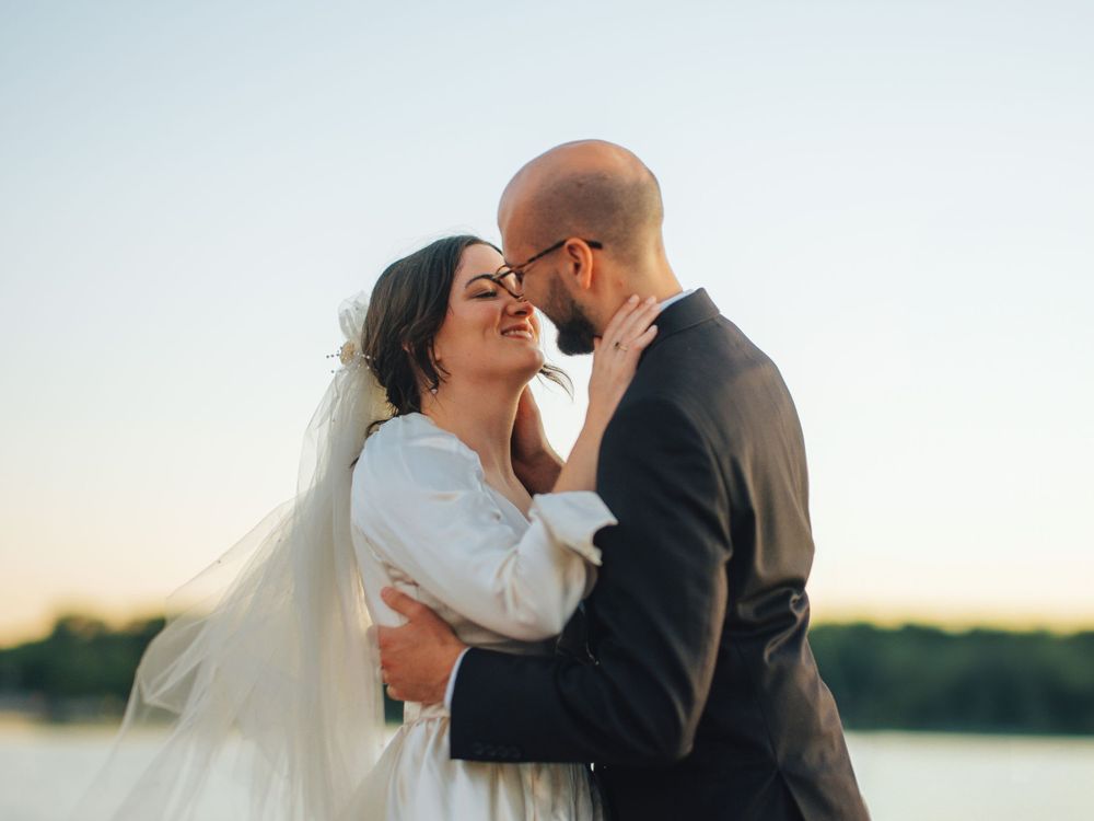 A romantic embrace between newlyweds during a sunset boat session.
