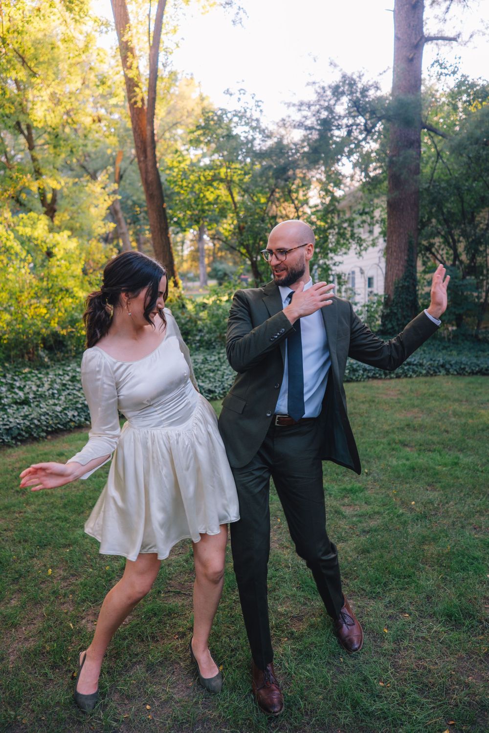 A whimsical dancing moment captured in a lush garden setting during golden hour.
