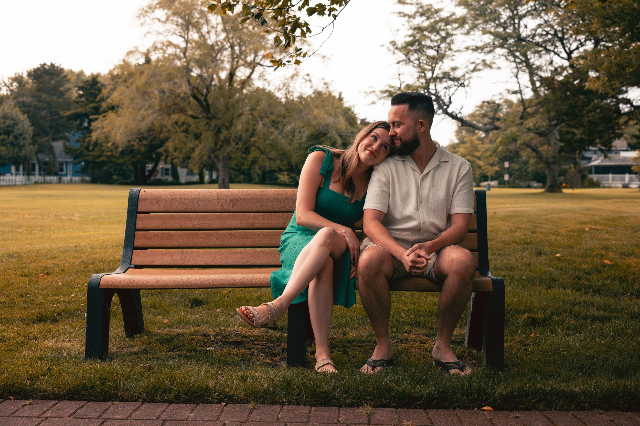 Intimate moment shared on a park bench during golden hour.
