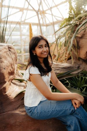 Portrait in greenhouse with natural lighting and desert plants.