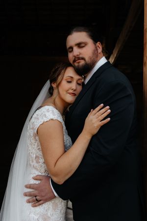 Intimate wedding portrait of couple in traditional attire sharing tender moment.