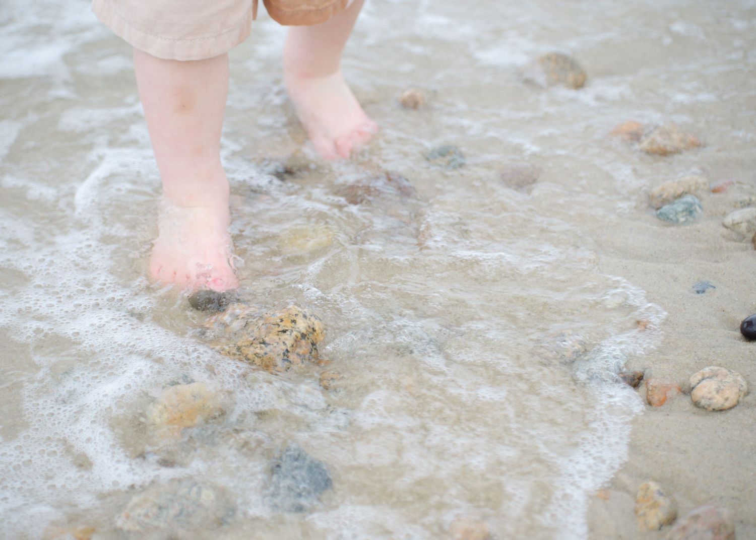 Relaxed moment, close-up of feet strolling through tide at sunset on Cape Cod.