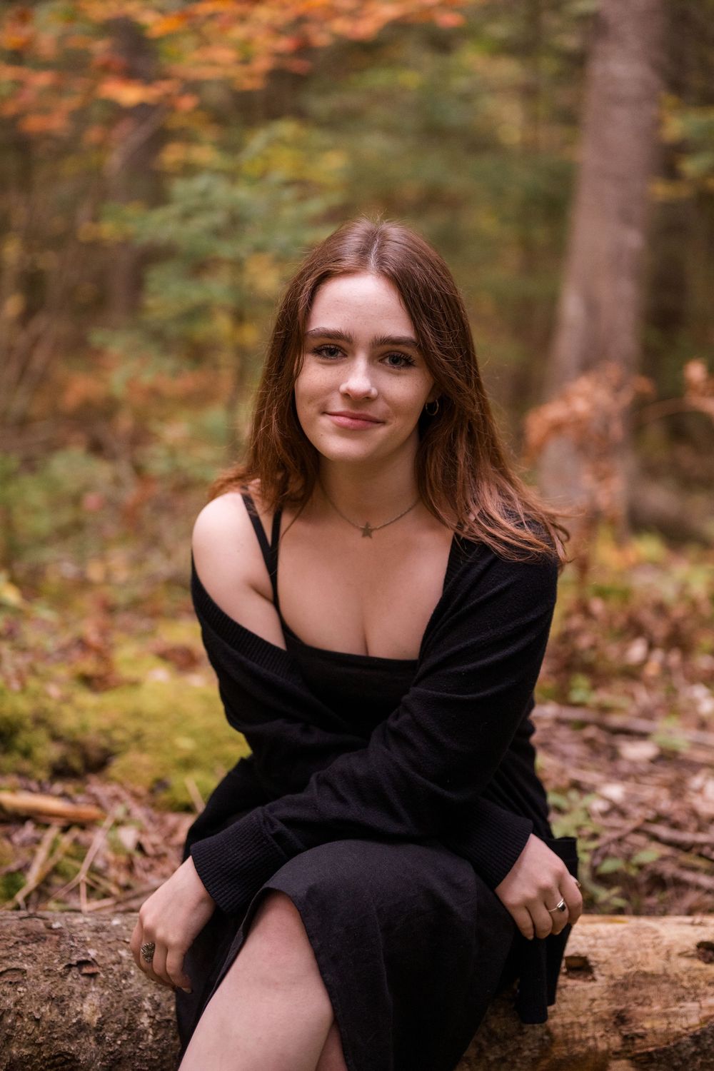 A series of outdoor portrait photographs featuring someone in a black dress sitting on a fallen log in an autumn forest setting.