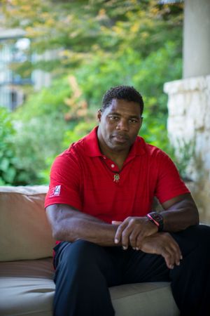 Athletic person in red polo shirt sitting on outdoor patio furniture.