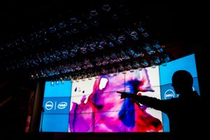 Stage setup with Dell and Intel branding displaying colorful visuals on large screens.