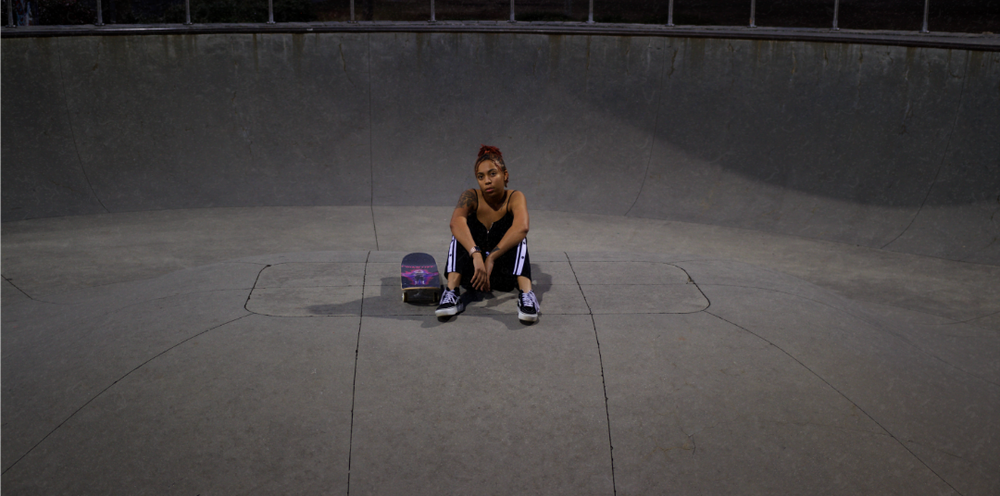 Candid lifestyle photo of skater sitting on board at Griffin skate park