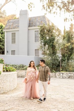 Couple in casual formal wear walking together near white building.