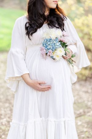 Close-up of maternity dress with delicate blue and pink floral bouquet.
