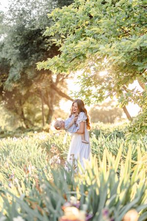 Candid moments captured in a garden setting with blooming iris flowers and golden sunlight.