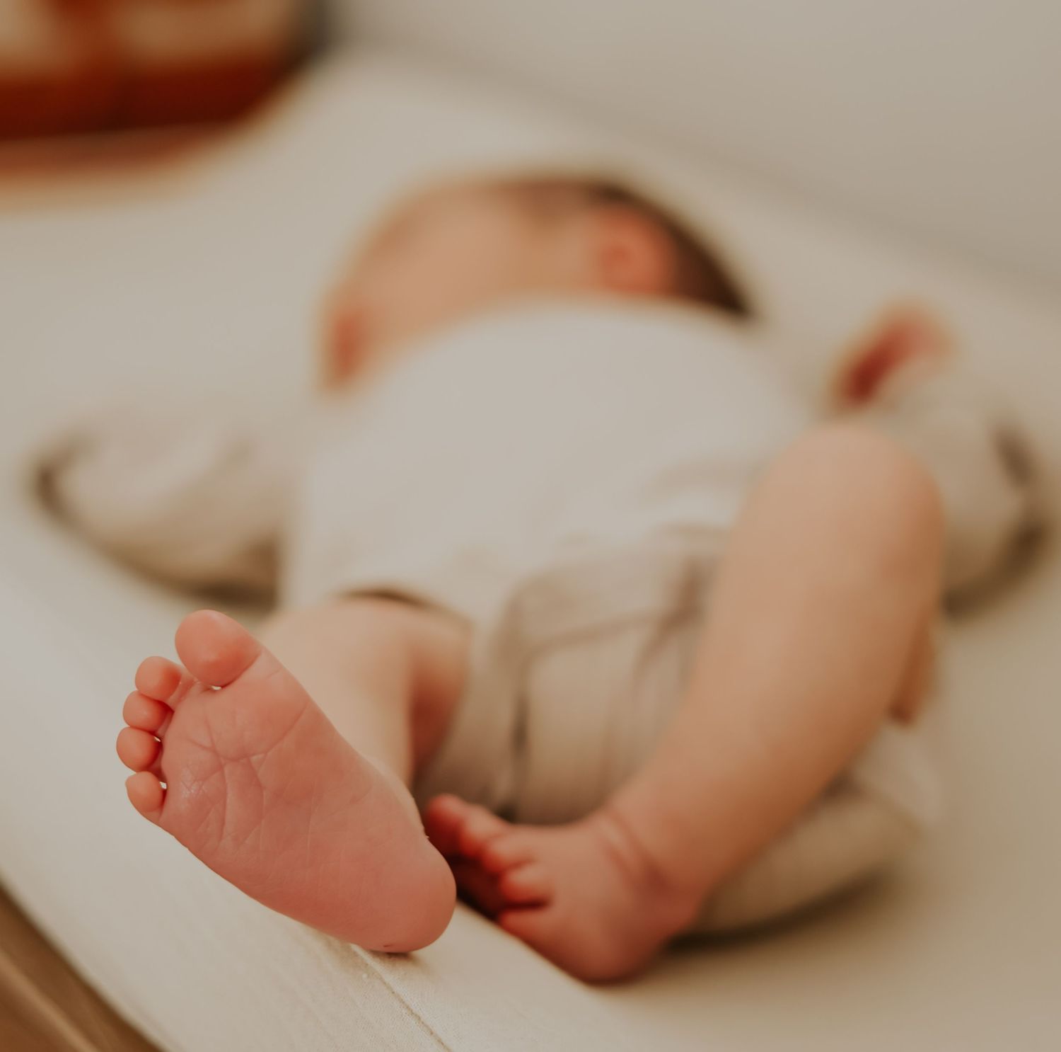 Close up of tiny newborn baby feet against white background.