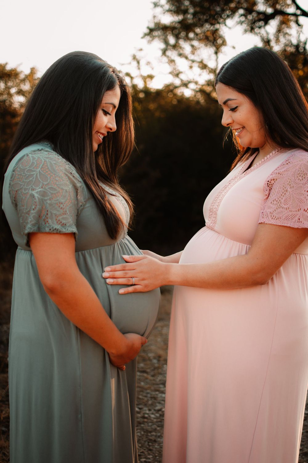 twin sisters experiencing motherhood together for the first time during a maternity session in DFW in an outdoor maternity photoshoot