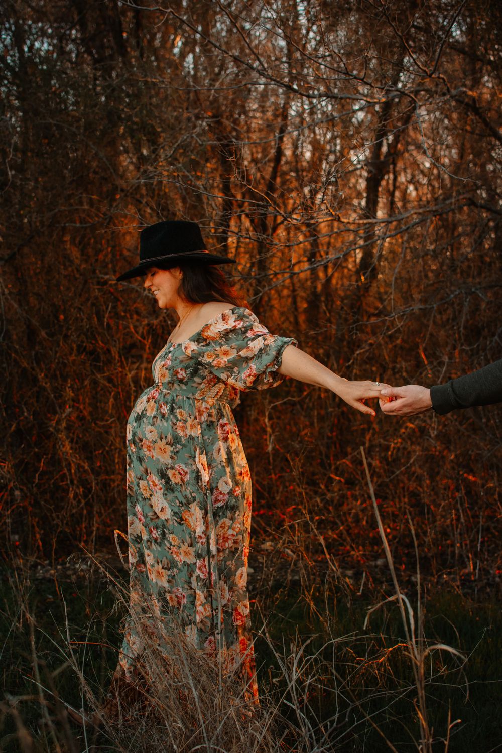 Editorial maternity session in Dallas–Fort Worth surrounded by trees and warm ambient light