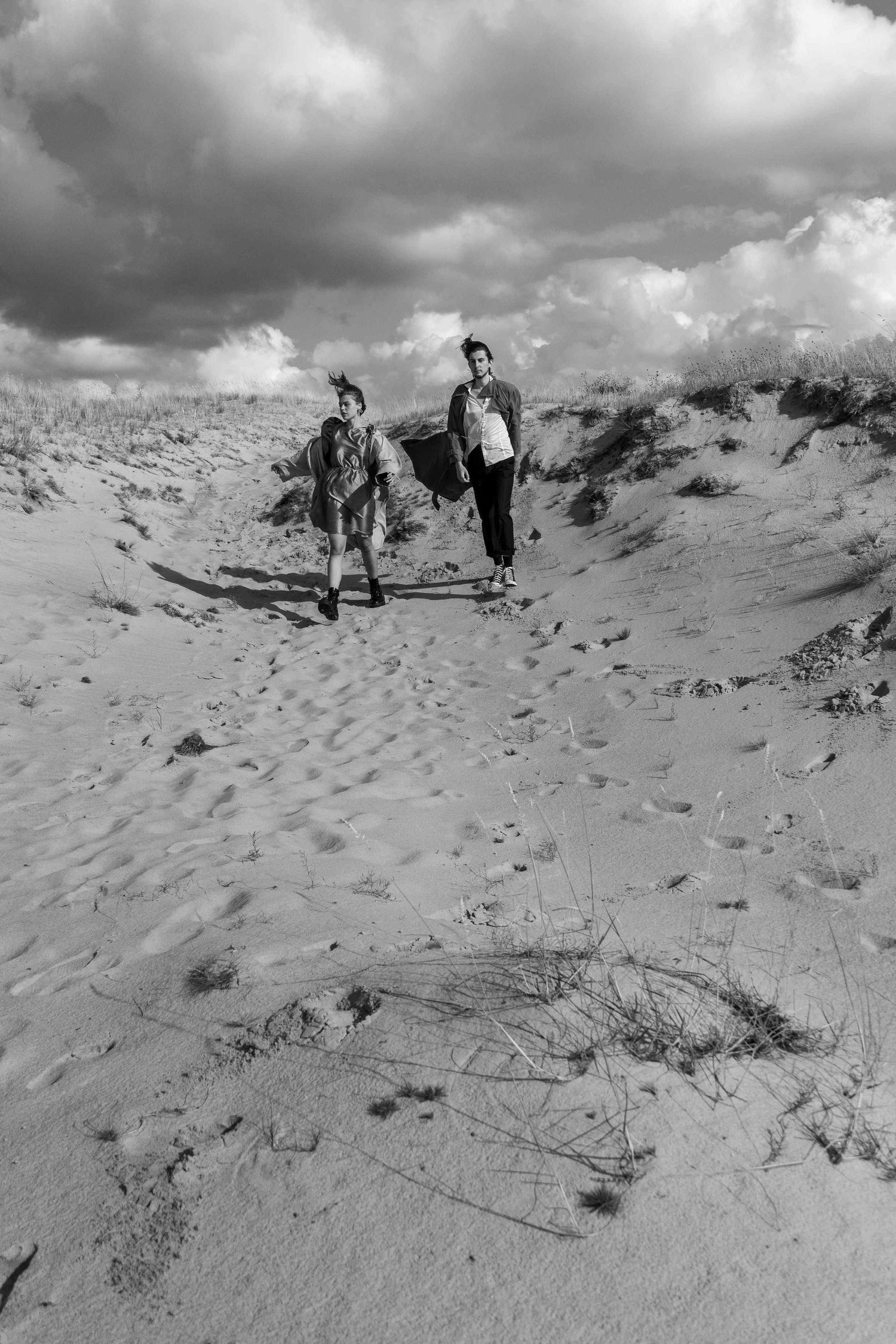 A woman and a man are holding hands and walking at the seaside.