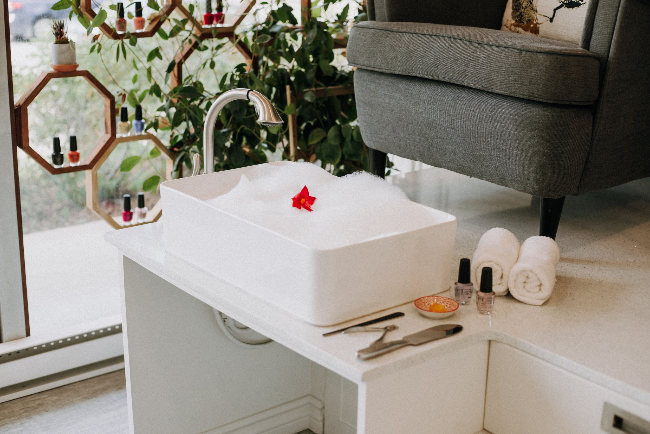 White storage box with beauty products and supplies on counter near window.
