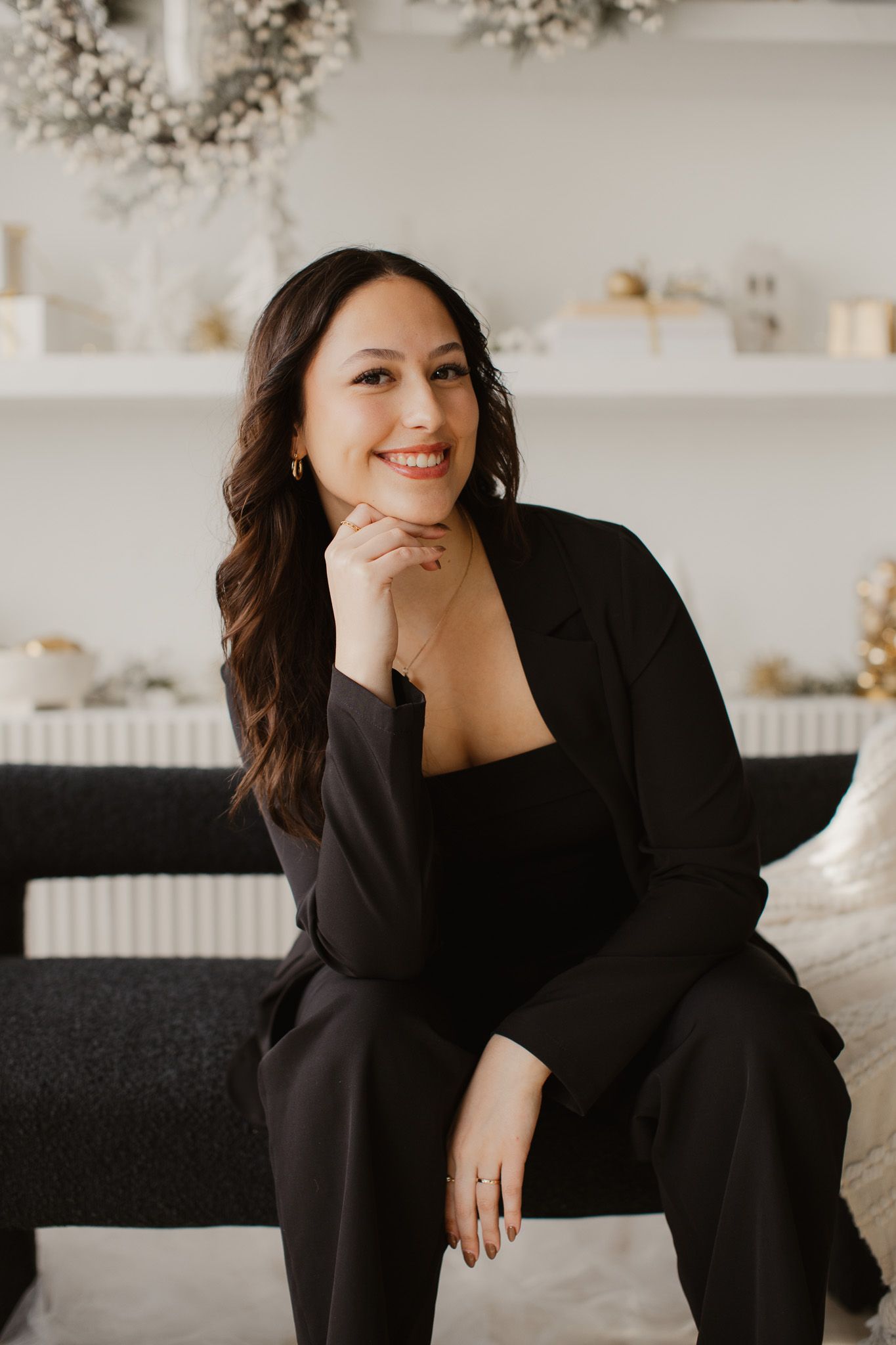 Professional portrait in cozy room with white decor and wreaths.