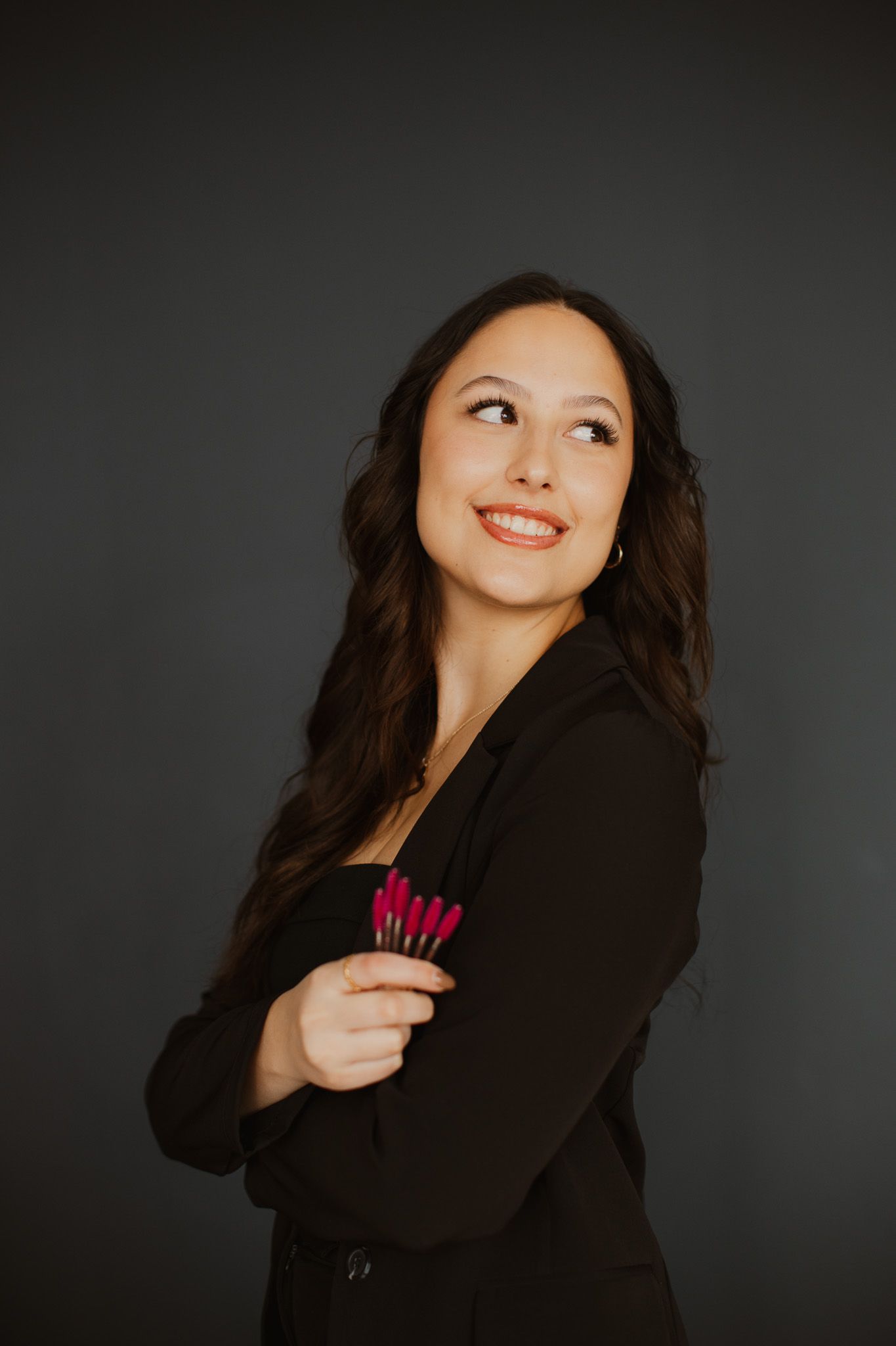 Professional studio portrait against dark background with warm lighting.