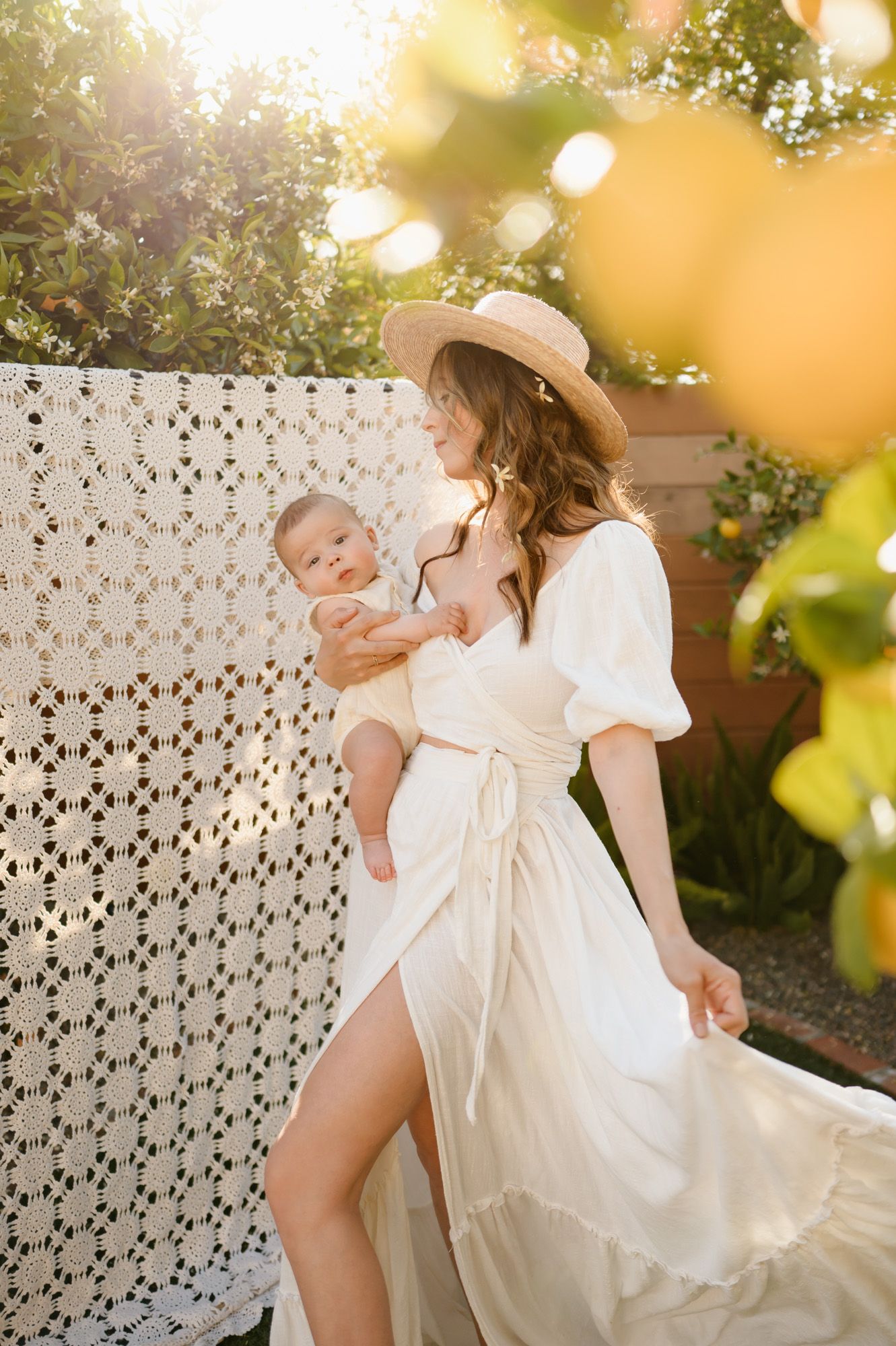 Santa Barbara boho mommy and me photoshoot by Ventura family photographer of woman with baby in citrus trees grove in Ojai
