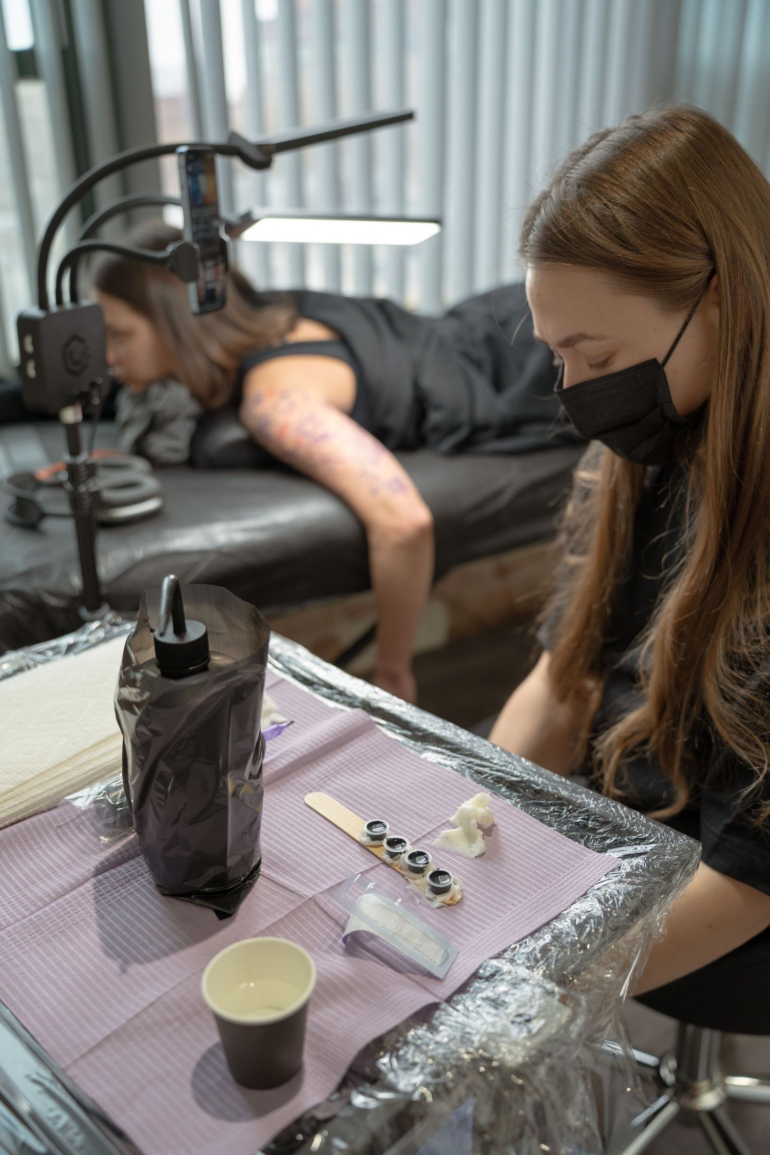 Professional tattoo workspace with supplies and equipment on covered table.