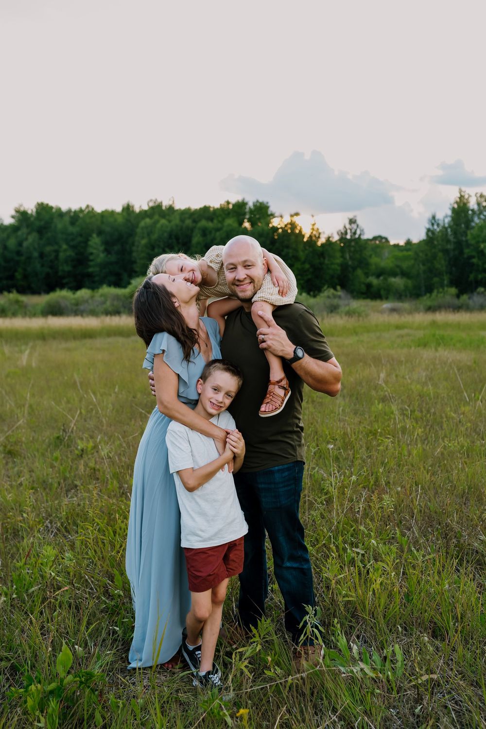 Family of four laughs together during photos