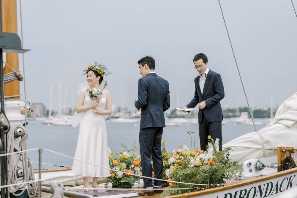 Waterfront wedding reception setup on a dock with elegant table settings.