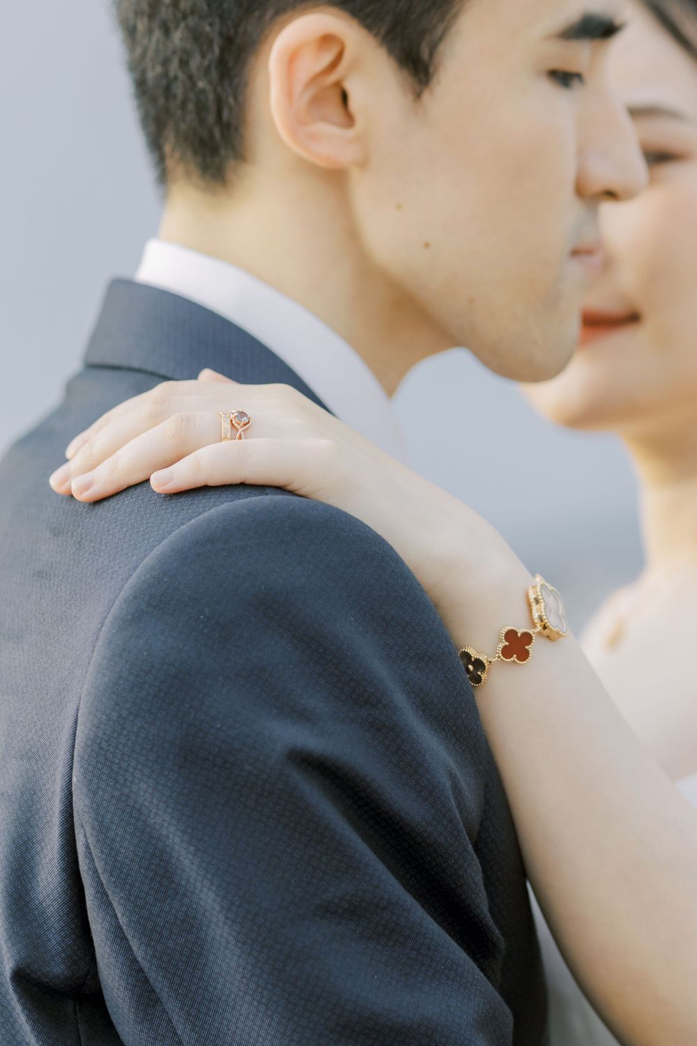 Close-up of elegant bridal jewelry and formal attire during an intimate wedding moment.