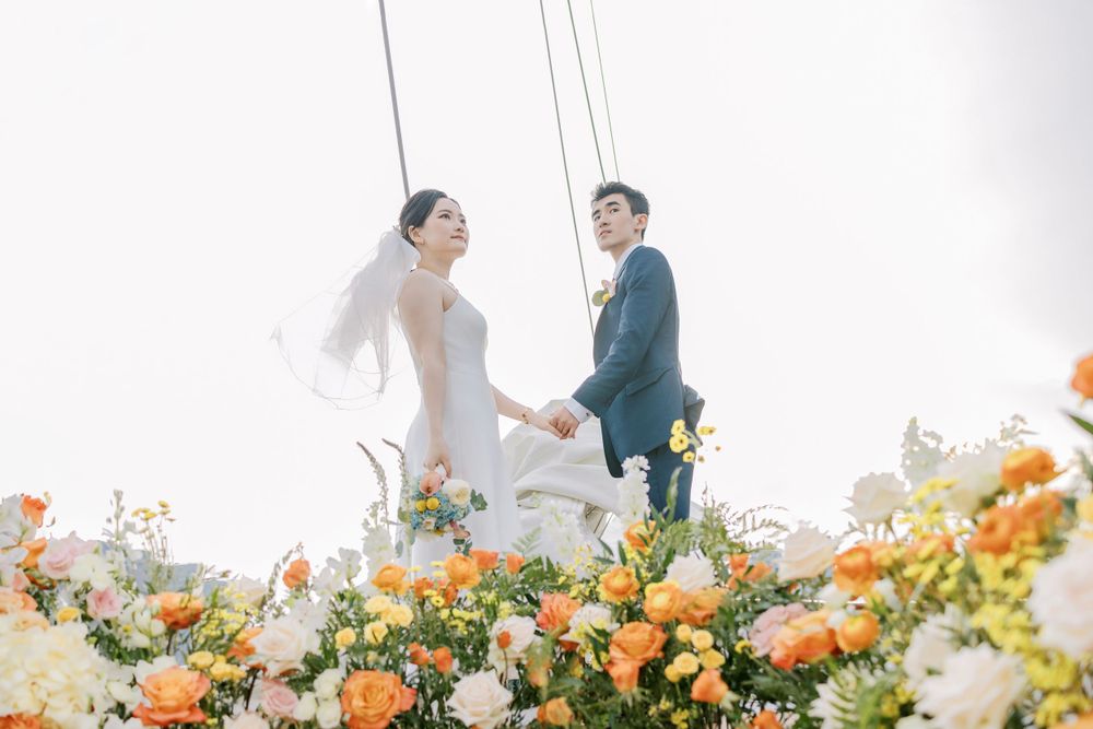 Romantic wedding ceremony on a yacht adorned with lush orange and yellow florals.