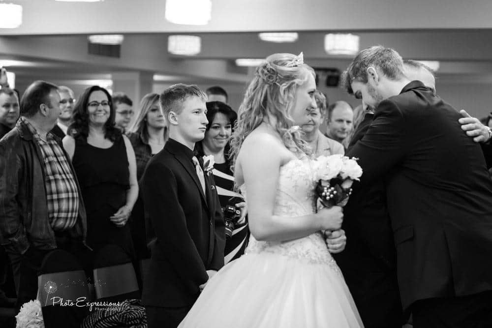 Black and white candid moments from wedding reception with guests celebrating.
