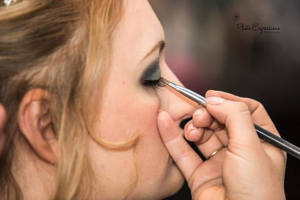 Close-up shots showing the application of eye makeup with brushes and cosmetics.