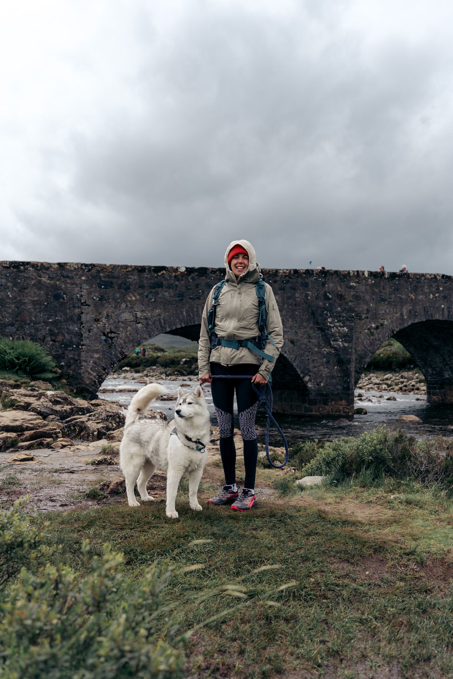 randonneuse avec son chien devant le sligachan bridge sur l'île de skye en ecosse