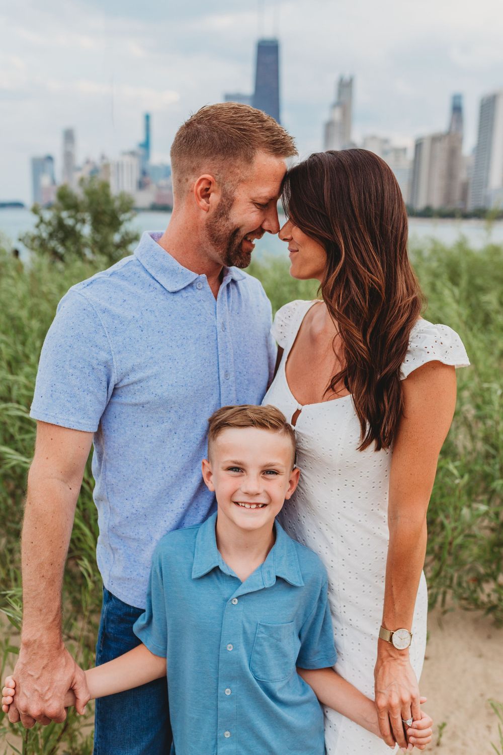 Happy family moment captured on beach with Chicago's iconic buildings in background.