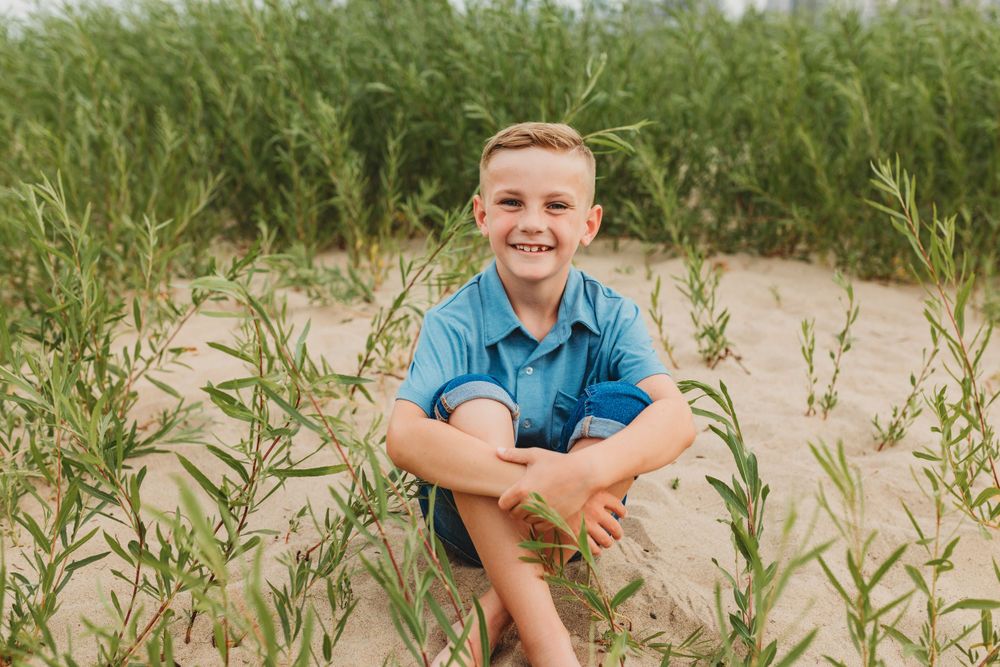 Beach grass frames candid family moments with city buildings in background.