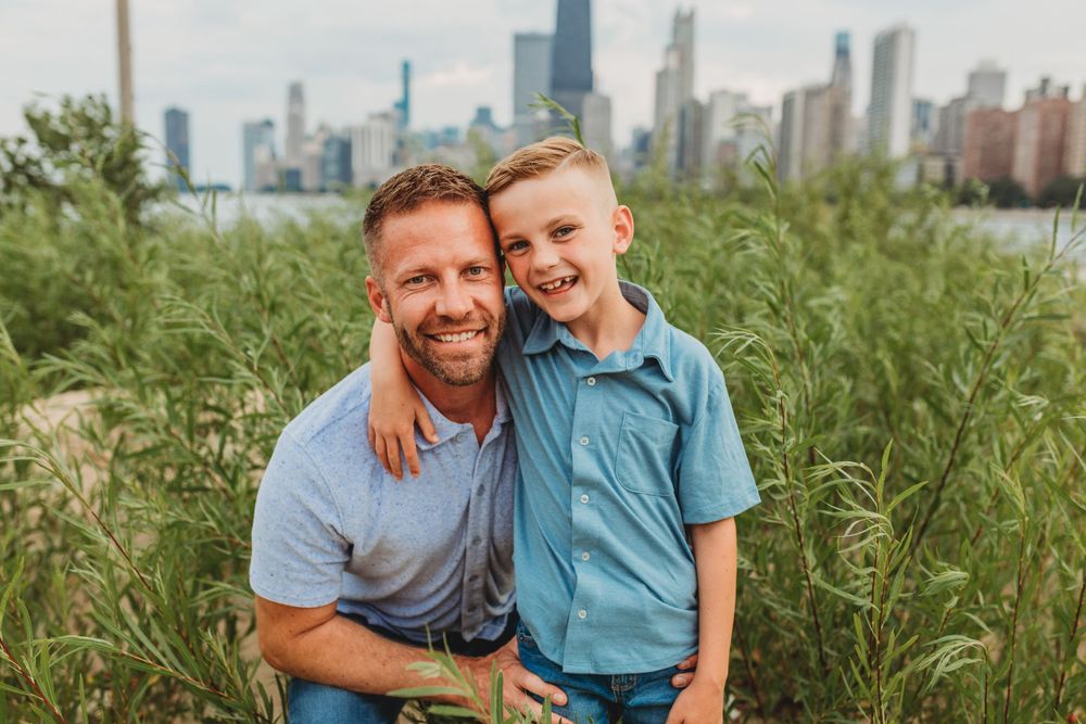 Family portrait session with city skyline visible in the background on a sunny day.