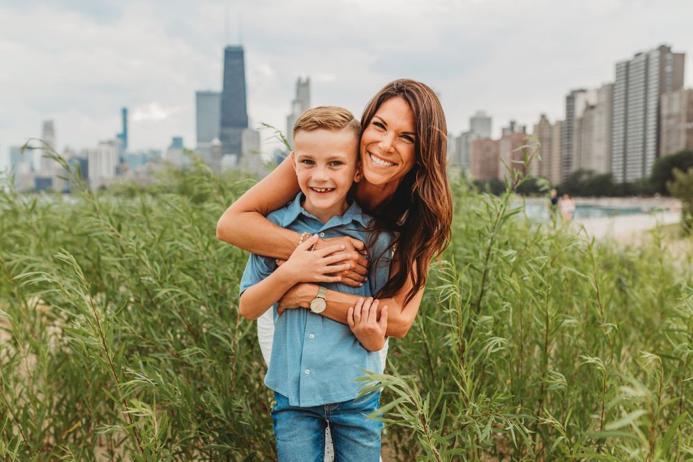Playful family interactions on sandy beach with Chicago's distinctive architecture visible.