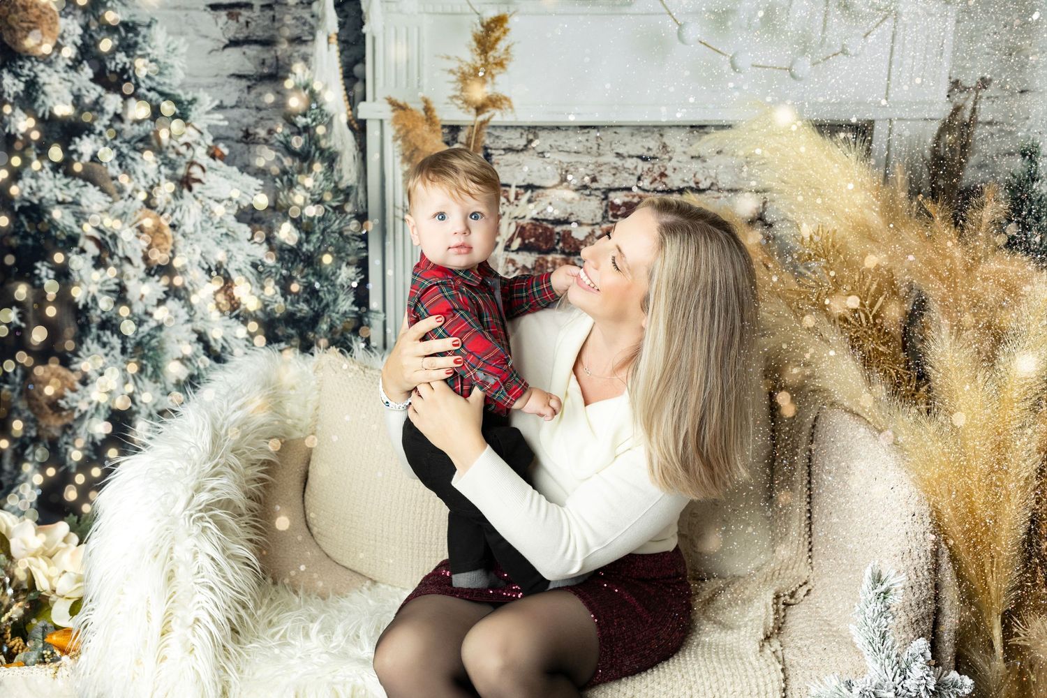 Cozy holiday portrait session with white Christmas tree and pampas grass decor.