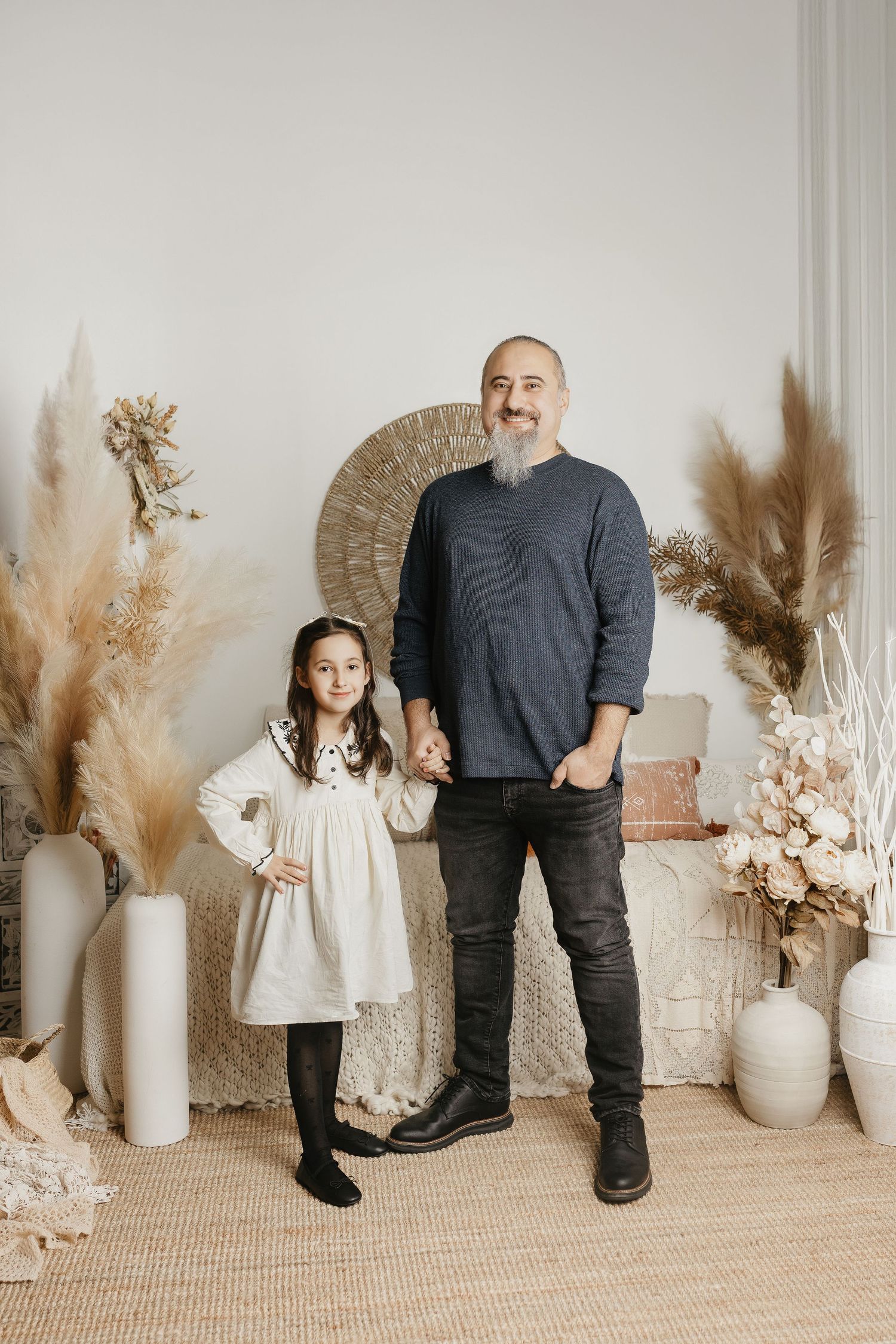 A heartwarming portrait against a neutral backdrop with pampas grass and decorative elements.