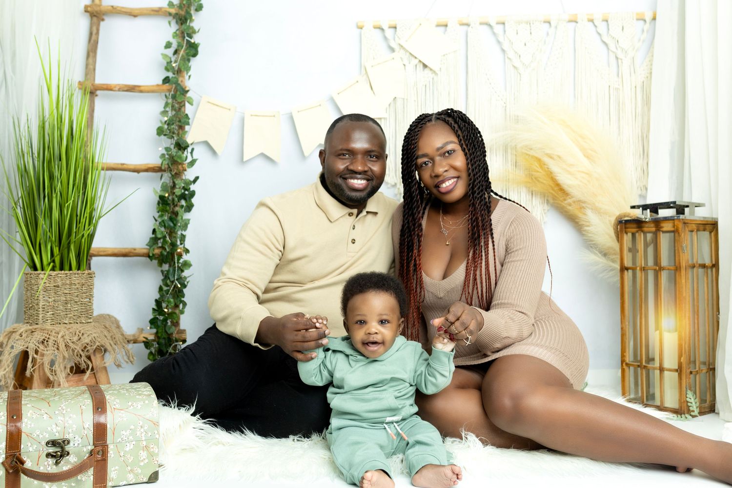 Family portrait with natural decor elements and white backdrop.
